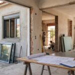 Ανακαίνιση κατοικίας σε εξέλιξη: εργάτες σε κλειστό σπίτι με νέα κουφώματα και υλικά οικοδομής